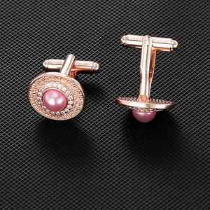 Gemelli da polso in oro rosa con perla rosa e pavé di cristalli su sfondo nero