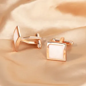 Macro shot of rose gold cufflinks with white enamel square inlay and spiral texture