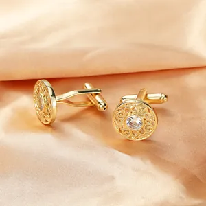 Detail of luxury gold-plated copper cufflinks with hollow pattern and zircon center