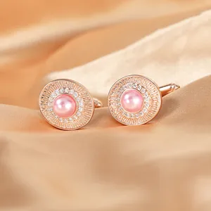 Dettaglio gemelli in oro rosa con perla rosa centrale e alone di zirconi lucidi