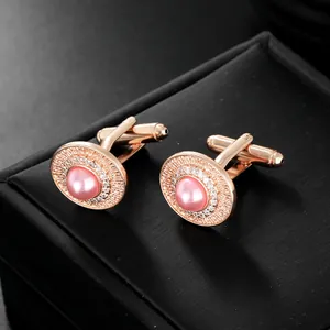 Dettaglio macro dei gemelli in oro rosa con perla rosa e cornice di cristalli