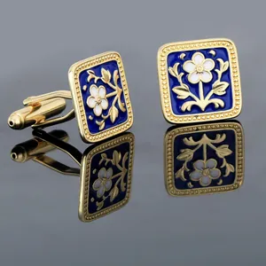 Detailed close-up of golden floral cufflinks with blue enamel finish and beaded edges