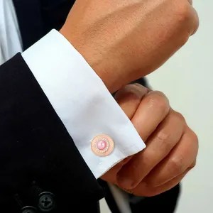 Gemelli in oro rosa con perla rosa e zirconi su polsino di camicia bianca