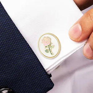 Elegant gold oval cufflinks with pink rose motif on white shirt and blue suit jacket