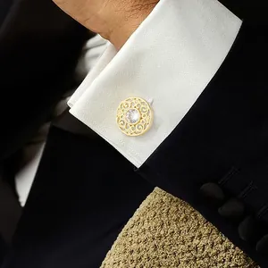 Classic gold hollow cufflinks with center crystal on white shirt and black suit sleeve