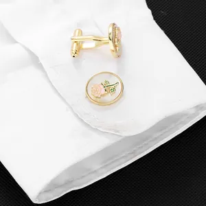 Detail of rose cufflinks with pink flowers on white shirt cuff over black background