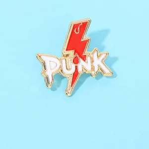 Détail d'un pin's émaillé en forme d'éclair avec texte PUNK et bordure métallique dorée