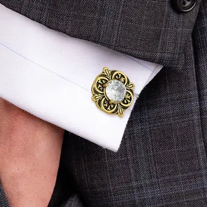 Elegant gold vintage cufflinks with transparent crystal on a white shirt and grey suit jacket