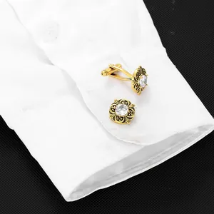 Detail of vintage gold cufflinks with white zircon on a white dress shirt sleeve