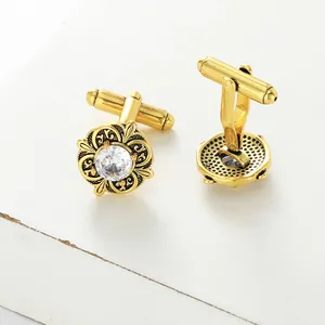 Detailed macro view of gold-tone floral cufflinks with sparkling center zircon crystal