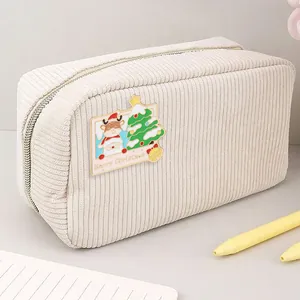 Detail of beige corduroy pouch featuring a Christmas tree and reindeer patch embroidery