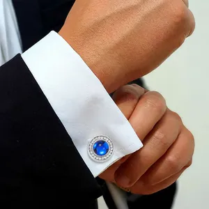 Elegant silver round cufflinks with blue gemstone and white rhinestones on white shirt