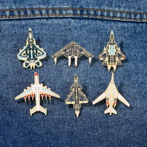 Lot détaillé de 6 pin's en émail d'avions militaires sur un fond en tissu denim bleu
