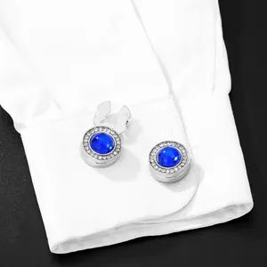 Detail of silver round cufflink with large blue crystal and white zircon pavé border