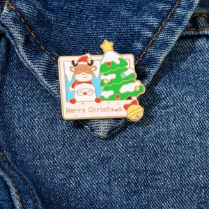 Macro detail of Polaroid style Christmas enamel brooch on blue denim jacket