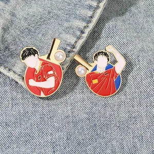 Ping pong metal badge set with enamel finish and pearl details on denim fabric