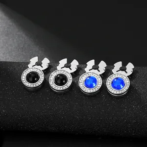 Macro detail of silver cufflinks with rhinestone rings and blue or black gem centers