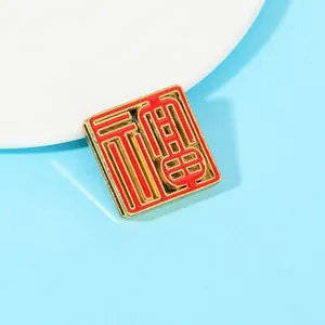 Detail of square gold metal fridge magnet with red enamel and Chinese Fu character