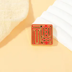 Macro shot of square gold and red metal pin with artistic Chinese Fu character engraving