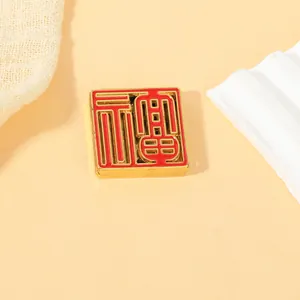 Detail of square gold metal fridge magnet with red enamel Fu character on a tray