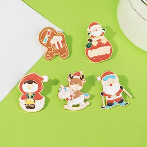 Detail of five Christmas enamel pins including Santa and snowman on green background
