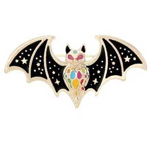 Broche chauve-souris vintage avec émail coloré et étoiles dorées sur fond blanc
