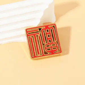Square gold-tone metal fridge magnet with red enamel Fu character for good fortune
