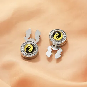 Gros plan détaillé de boutons de manchette argentés avec motif Tai Chi et cercle de strass