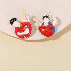 Detail of red enamel table tennis brooches with gold plating and pearl accents