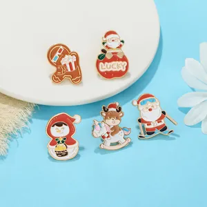 Set of five Christmas enamel pins including Santa and gingerbread man on blue background
