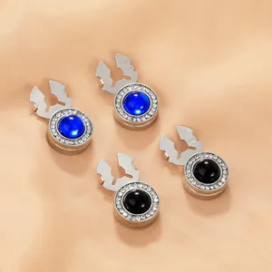 Close-up of sparkling rhinestone cufflinks in blue and black on elegant silk fabric