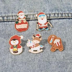 Detail of Christmas enamel pins featuring Santa and gingerbread man on denim fabric