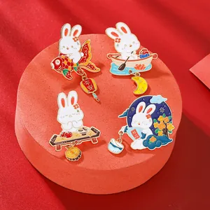 Set of four cartoon rabbit enamel pins in traditional Chinese style on red display