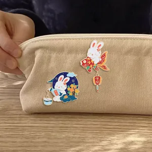 Cute enamel rabbit pins with lucky koi and osmanthus wine designs on canvas bag