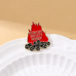Detailed view of red enamel campfire pin badge with Midnight Society Member engraving