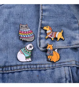 Detailed view of four colorful enamel animal pins on blue denim fabric background