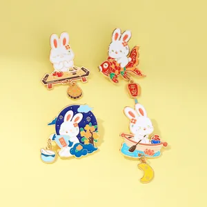 Detail view of four cartoon rabbit enamel pins with traditional koi and lantern motifs