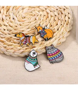 Detail view of four winter animal enamel pins on a woven mat with warm textures
