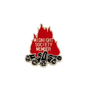 Midnight Society Member bonfire enamel pin with red flames and gold lettering on white background