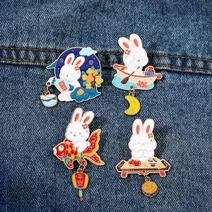 Set of four cute cartoon rabbit enamel pins with koi and moon elements on denim