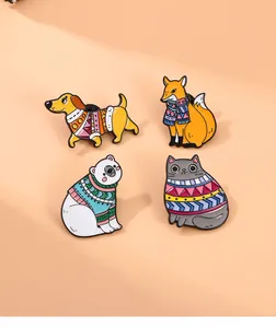 Detail view of four winter-themed enamel pins featuring a dog, fox, bear, and cat