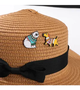 Macro shot of cartoon enamel pins featuring a polar bear and dachshund dog on a straw hat