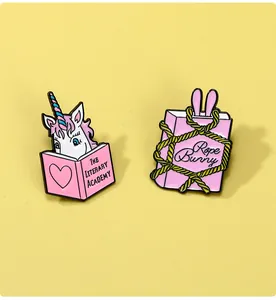 Details von pinkfarbenen Einhorn- und Rope Bunny-Emaille-Anstecknadeln auf Gelb