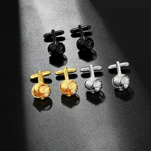 Detailed macro shot of braided metal knot cufflinks in matte black, gold, and silver finishes