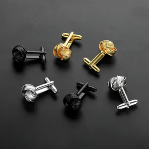 Macro detail of three pairs of metallic twisted knot cufflinks in gold silver and black