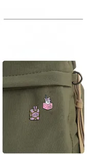 Detailaufnahme der Emaille-Broschen in Buchform mit Hasen- und Einhorn-Motiven