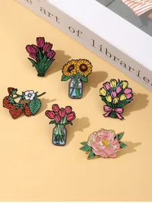 Detailed view of colorful tulip and sunflower enamel pins on a minimal aesthetic background
