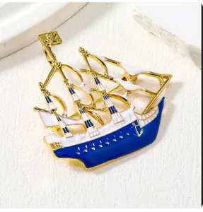 Macro detail of a nautical pirate ship brooch with blue and white enamel on a gold frame