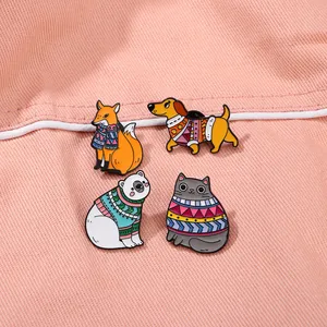 Cute enamel pins featuring cartoon fox, dachshund, polar bear, and cat in winter sweaters