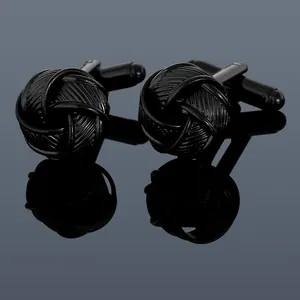 Close-up of black silk knot style cufflinks with textured metallic finish for men's shirts
